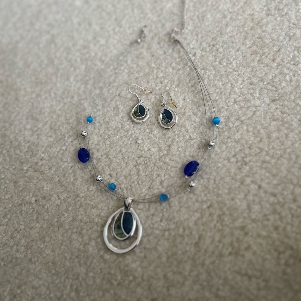 Silver colored necklace with blue and green stone and matching earrings